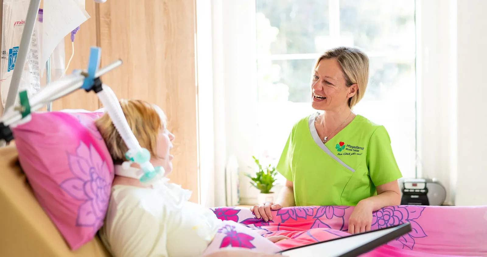 Pflegekraft am Bett eines beatmeten Kindes