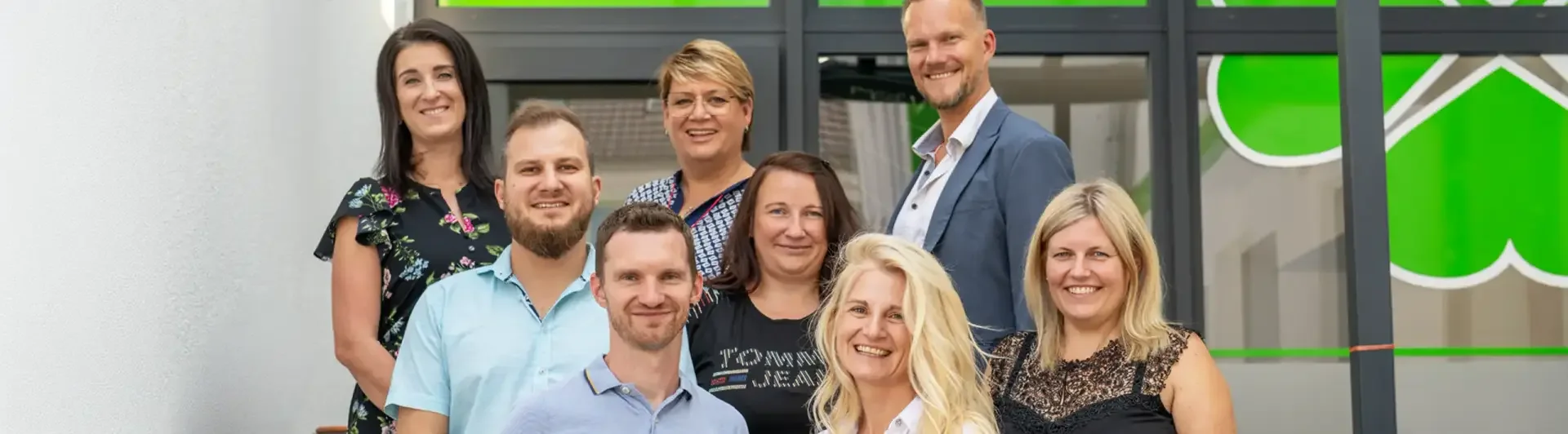 Gruppenfoto des Teams vom Pflegedienst Nicole Tobias vor dem grünen Kleeblatt